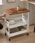 Three Tier Rolling Side Table With Lockable Casters And Spacious Storage Shelves For Hassle Free Room To Room Moving Everyday Utility Cart Stand For Home Organization Built Tough For Any Space with books and a blanket.