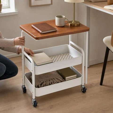 Three Tier Rolling Side Table With Lockable Casters And Spacious Storage Shelves For Hassle Free Room To Room Moving Everyday Utility Cart Stand For Home Organization Built Tough For Any Space with books and a blanket.