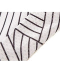 Close-up of a white fabric with black stripes, showing textured material and design pattern.