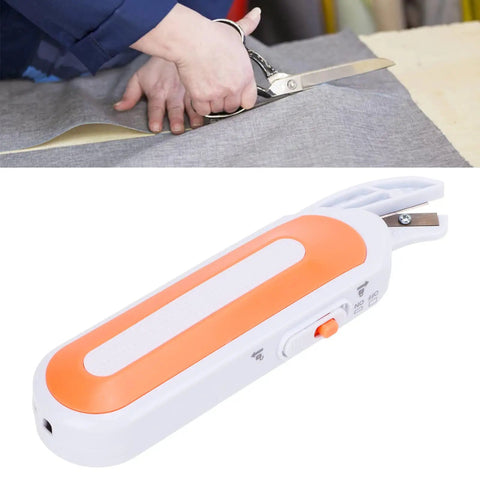 Cordless Electric Scissors For Cutting Fabric And Thick Leather Grab And Go Power Shears with orange handle cutting gray fabric.