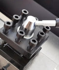 Metal lathe tool post assembly on bench lathe, black base with six hex-socket screws and silver knob