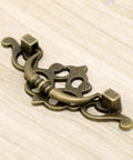 Vintage Antique Brass Bail Pull Handles Set For Wooden Drawers Cabinets And Cupboards Four Pack With Distressed Zinc Alloy Finish And Anti Rust Durability Includes 3.8 Inch Length 1.6 Inch Height Center To Center 2.6 Inch Spacing For Retro Decor close-up view."}