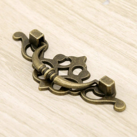 Vintage Antique Brass Bail Pull Handles Set For Wooden Drawers Cabinets And Cupboards Four Pack With Distressed Zinc Alloy Finish And Anti Rust Durability Includes 3.8 Inch Length 1.6 Inch Height Center To Center 2.6 Inch Spacing For Retro Decor close-up view."}