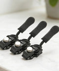 Three black Zipper Repair Kit Puller Replacement Tool Three Piece Set with Easy Grip Design shown on a white surface.