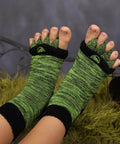 Close-up of feet wearing Foot Alignment Socks With Toe Separators For Men And Women, green and black color; breathable design.