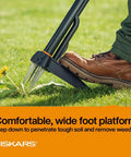 Stand-Up Weed Puller Tool With 4 Serrated Claws, Reinforced Foot Platform pressing into soil with boot