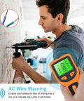 Man using 5 in 1 Wall Stud Finder Sensor with Backlit Display near wall, showing AC wire detection feature.