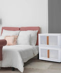 Built Tough Plastic Storage Bins With Lids 3 Pack stacked next to a bed, featuring clear doors and wood handles.