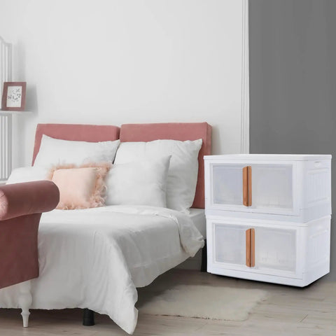 Built Tough Plastic Storage Bins With Lids 3 Pack stacked next to a bed, featuring clear doors and wood handles.