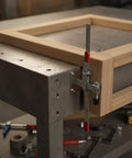 Heavy Duty Stainless Steel Vertical Toggle Clamp Jobsite Tough Side Mount Lever securing wood frame on workbench.