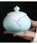 Airtight Ceramic Coffee Canister Porcelain Tea Caddy With Tight Seal Lid Keeps Your Stash Fresh As A Dime For Kitchen Pantry Organization Blue Jar held in hand.