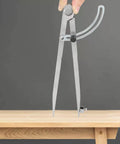 Tough As Nails All Metal Drafting Compass With Adjustable Wing Divider and Secure Pencil Holder in use, drawing circle on wood.