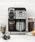 Two In One Coffee Maker With Ten Cup Thermal Carafe And Single Serve Brewer With Over Ice Function Fully Automatic Pod And K Cup Compatible For Four To Twelve Oz Brews Black And Stainless Finish shown with coffee accessories on a counter.