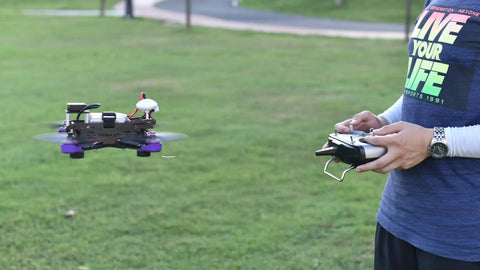 Person using R8SM 2.4 GHz 8 Channel Mini Receiver For FPV Drones With SBUS PPM Long Range Control Ultra Tiny Size FHSS Anti Interference Technology Compatible With T8FB T8S Transmitters outdoors
