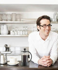 Man in kitchen with French Press Coffee And Tea Maker 12 Oz With Borosilicate Glass And Four Level Filtration System on counter.