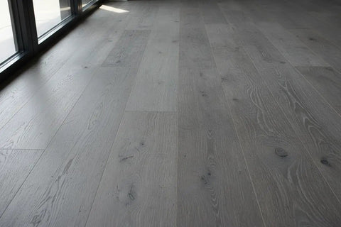 Heritage Gray Reactive Water Based VOC Free Interior Wood Stain 55 Gallon Tank applied on smooth gray wooden flooring.
