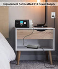 Front view of ResMed AirSense 10 power supply on a nightstand, with 24V AC adapter and external power brick.