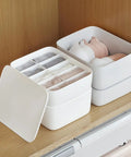 Stackable White Plastic Drawer Organizers For Bras Socks And Underwear Open Top Storage Bins on wooden shelf with sorted items.