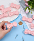 Hand holding Top Tier Pink Bow Ceramic Cabinet Knobs and Decorative Drawer Pulls with mounting screws for furniture updating.