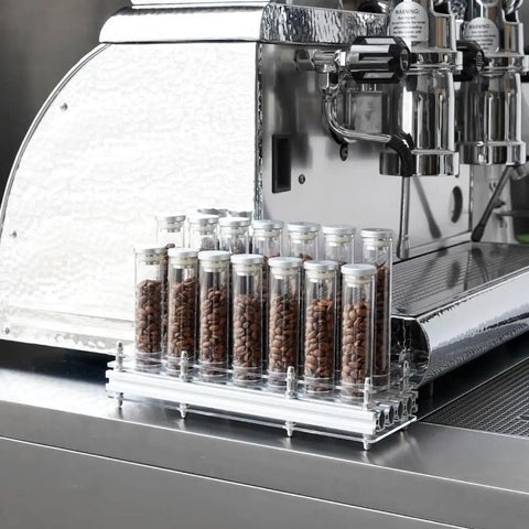 Single Dose Coffee Bean Storage Tubes, Glass And Aluminum Vials, Fourteen Piece Set With Acrylic Board displayed on espresso machine.