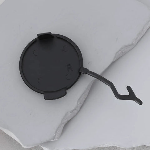 Right Side Tow Hook Eye Cover Cap For Porsche Cayenne 2011 To 2014 Rear Bumper Replacement 95850545000 shown on stone surface