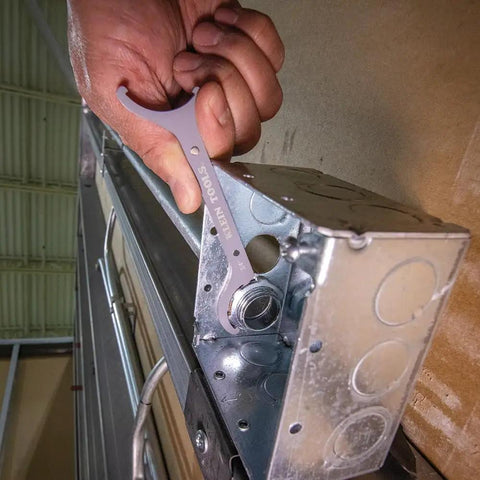 Conduit Locknut Wrench Set in Compact Alloy Steel Design With Magnetic Storage Built For Tight Spots includes one-half inch wrench being used