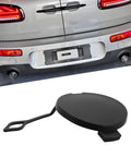 MINI Cooper Tow Hook Cover Cap 51121177907 Fits Front And Rear Bumpers For R50 R53 R52 R55 R56 R57 LCI Models Durable Plastic Build Easy Install Secure Fit. Black plastic tow hook cover cap, shown with silver MINI Cooper rear bumper.