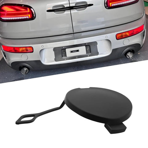 MINI Cooper Tow Hook Cover Cap 51121177907 Fits Front And Rear Bumpers For R50 R53 R52 R55 R56 R57 LCI Models Durable Plastic Build Easy Install Secure Fit. Black plastic tow hook cover cap, shown with silver MINI Cooper rear bumper.