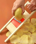 Manual stainless steel wave crinkle cutter in a wooden frame for crinkle-cut potatoes and vegetables.