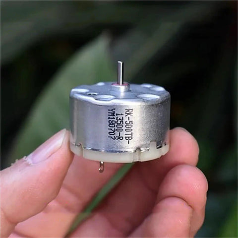 Mini 32mm Round Spindle Motor, DC 6V 9V 12V, 5600 RPM, held between fingers, showing compact design with visible shaft and markings