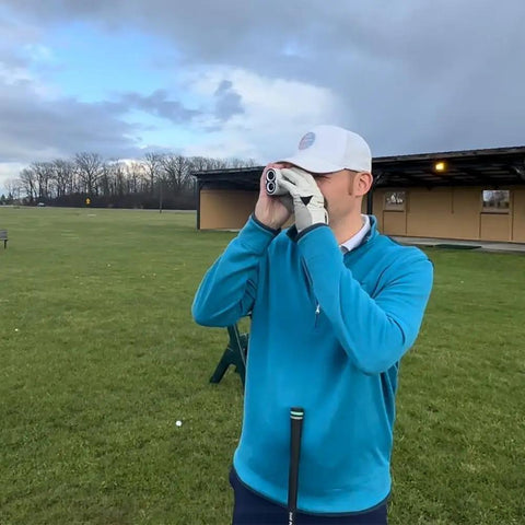 Person using a Golf Range Finder With Magnetic Mount Slope Compensation Flag Lock Vibration Measures In Yards Feet And Meters 1000 Yard Range USB C Rechargeable Battery And Top Notch Optics on a golf course