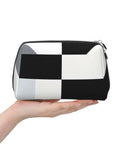 Hella Chic Black And White Piano Key Print Travel Makeup Bag in hand, durable PVC pouch for organizing brushes and skincare.