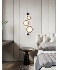 Top Shelf Modern Wall Sconce With Straight Fire Led Glow And Hella Sturdy Iron Frame Perfect For Bedroom Bedside Or Tv Backdrop Ambiance Easy Surface Mount And Super Durable Daily Lighting mounted beside a bed, featuring black iron and round LED lights.