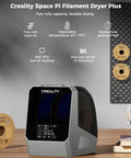 Creality Space Pi Filament Dryer Plus with dual roll capacity and LCD touch screen, featuring 360° PTC hot-air heating, on a wooden table.