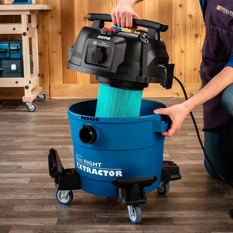 9 Gallon HEPA Dust Collector Auto Starts With Your Power Tools being used to insert a washable filter into blue heavy duty vacuum.