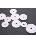9 White plastic gears of varying sizes for precision applications in machinery, compatible with 6 By 10 Inch Mini Metal Lathe Runs Smooth As Silk Precision Threading.