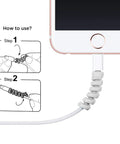 12 Piece Silicone Spiral Charging Cable Protectors For Micro USB And USB Cords, Dope Cable Saver And Shield To Keep Cables Tangle Free, For Phones, Laptops, And Computers, Gray And Black applied to a smartphone cable showing installation steps.