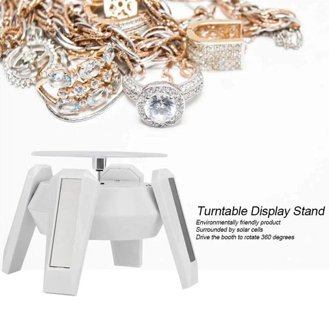 Solar Powered Jewelry Display Stand With 360 Degree Rotating Turntable And Blue LED Lights Electric Base showcasing rings and chains.