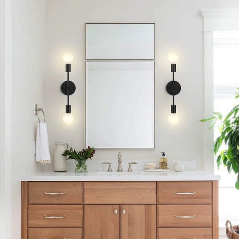 Dual Light Bathroom Wall Sconce Vanity Fixture In Gold And Black Finish installed vertically on bathroom wall.
