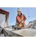 Worker cutting concrete with Flexvolt 9 Inch Diamond Cutting Wheel For Masonry And Concrete With Seven Eighths Inch Arbor 6600 Max RPM