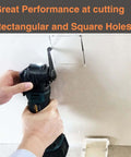 Drywall blade for oscillating tool cutting a rectangular hole in drywall; cordless teal-and-black multi-tool in use