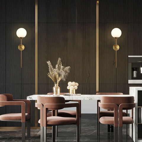 Gold Glass Globe Wall Sconces Set Of 2 Plug In Mid Century Modern Look in dining room with dark walls and brown chairs.