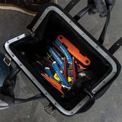 Heavy Duty Black Canvas Tool Bag With Wide Mouth Opening Leather Handles 12 Inch Tool Tote Multi Purpose Carryall For Tools Riveted Frame Vinyl Bottom For Durability, open showing assorted hand tools inside.