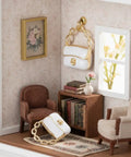 Miniature 1:12 scale white purse with chain for dolls on shelf in dollhouse, part of Three Pack Mini Handbag Set For Dollhouse Decor.