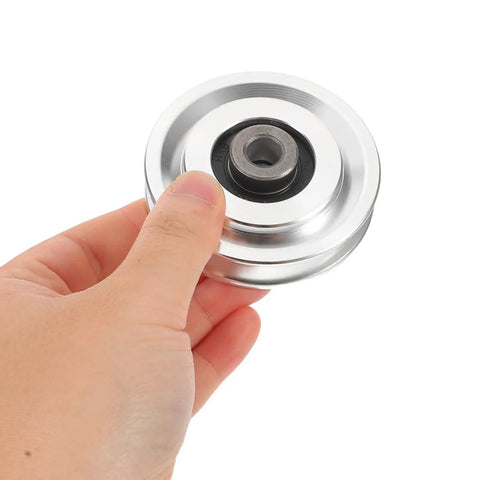 Hand holding Heavy Duty Aluminum Alloy Bearing Pulley Wheel For Gym And Home Cable Machines Universal Pull Down Attachment With Smooth Quiet Operation 70mm Outer Diameter For Sports Fitness Equipment