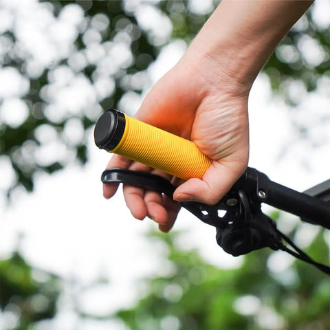 Close-up of hand gripping Yellow MTB Grips For Mountain Bikes And BMX With Double Aluminum Lock Ring outdoors on a bike