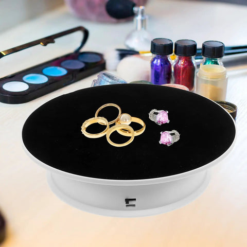 Ultimate 360 Degree Electric Turntable Rotating Display Stand With Two-Speed Adjustment For Jewelry Watches Photoshoot And Commercial Showcase Using White Base And Black Velvet Surface featuring rings and earrings on a velvet surface.