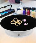 Sleek Electric Rotatable Jewelry Display Stand Turntable showcasing gold and silver rings on black velvet surface.