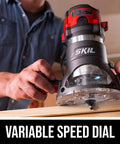 Close-up of a person using a Heavy Duty 10 Amp Fixed Base Corded Router With A Beefy Two Point Zero Horsepower Motor And Variable Speed Control for precise woodworking.