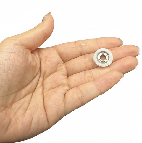 Rock Solid 5 Pack Nylon Pulley Wheels With Quiet Ball Bearings For U Groove Tracks held in hand, showcasing the size and detail.